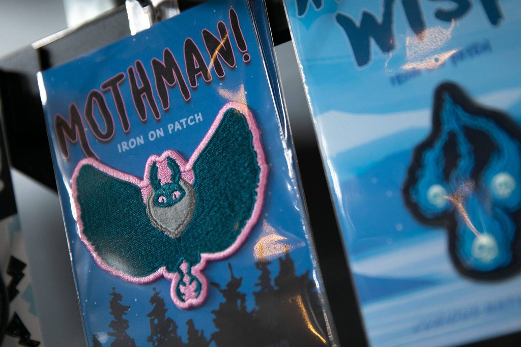 A Mothman patch designed by Danie Hadsall is sold alongside other patches, stickers and prints at Artisans PNW. (Ryan Berry / The Herald)