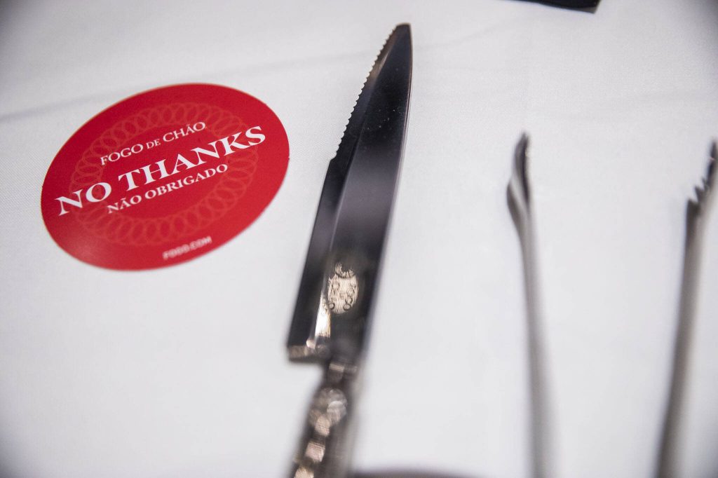 A small placard with green and red signal to the gauchos on if they can approach your table to serve you meat on Thursday, April 20, 2023 in Lynnwood, Washington. (Olivia Vanni / The Herald)