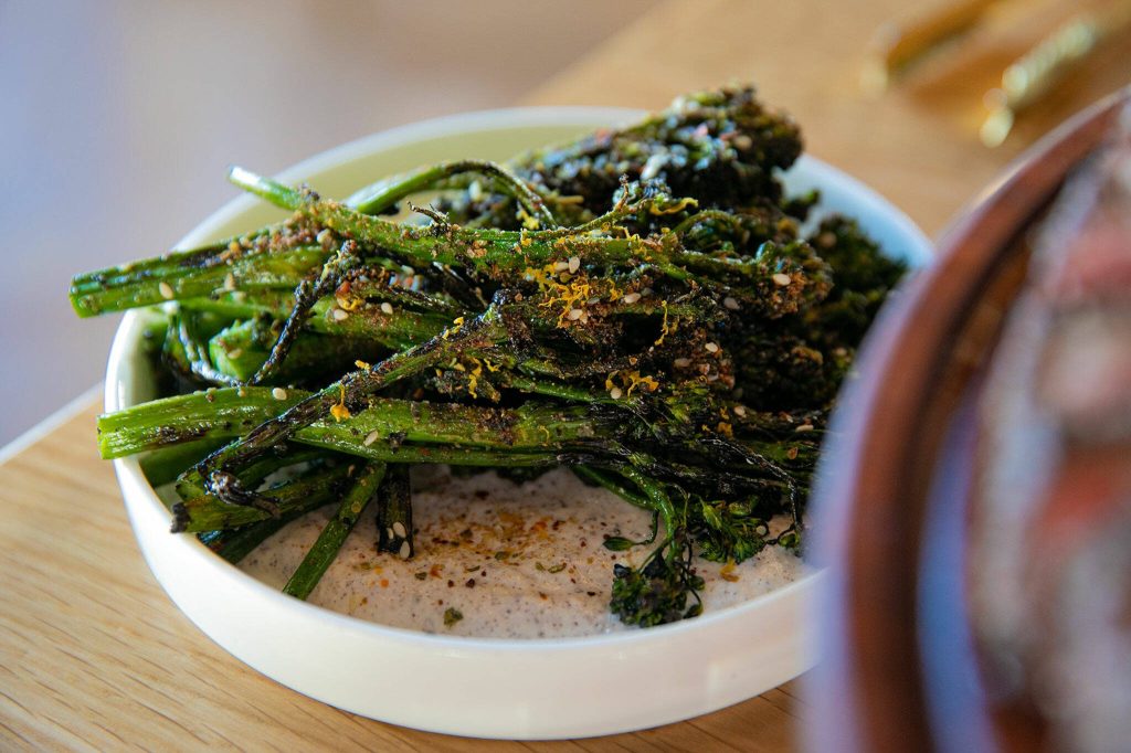 Wood Fired Broccolini atop yogurt offers a light side dish at Rare Society on Tuesday, April 25, 2023, in Mill Creek, Washington. (Ryan Berry / The Herald)