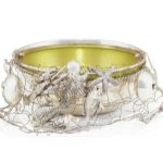 Three-dimensional silver figures of animals and wildlife are often seen on elaborate silver pieces. This bowl takes a slightly different approach, with figures of sea animals attached to a wire net.
