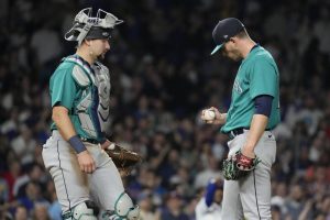 Seattle Mariners starting pitcher Chris Flexen, right, looks down as he listens to catcher Cal Raleigh after Chicago Cubs' Nelson Velazquez hit a grand slam during the third inning of a baseball game in Chicago, Tuesday, April 11, 2023. (AP Photo/Nam Y. Huh)
