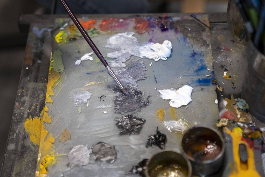 Bruce Rivera, 38, paints at Graphite Arts Center in Edmonds, Washington on Saturday, April 15, 2023. A silent auction of skateboard art will be held to raise money to kick-start Riveras new nonprofit, Salvage Arts. (Annie Barker / The Herald)