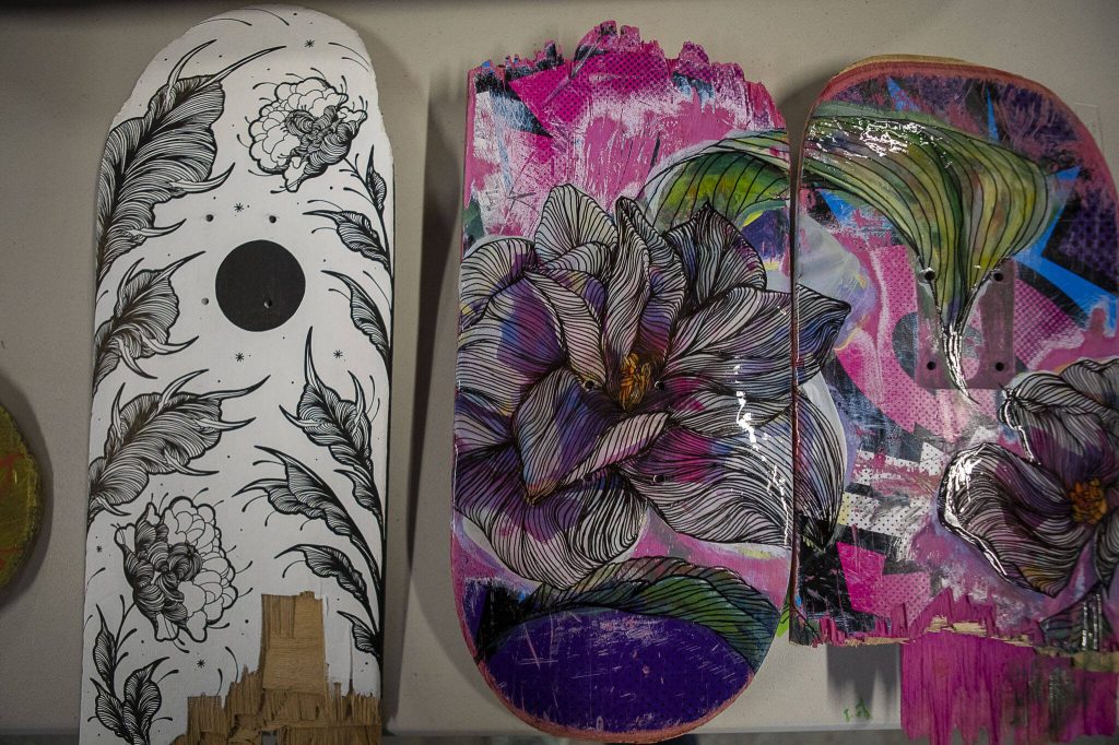 Skateboards by artists Rio Allen, left, and Dana Teruya Len, right, at Graphite Arts Center in Edmonds, Washington on Saturday, April 15, 2023. A silent auction of skateboard art will be held to raise money to kick-start Riveras new nonprofit, Salvage Arts. (Annie Barker / The Herald)