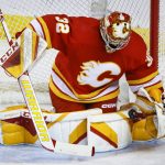 Flames goalie Dustin Wolf makes a save against the Sharks during the first period of a game Wednesday in Calgary, Alberta. (Jeff McIntosh/The Canadian Press via AP)