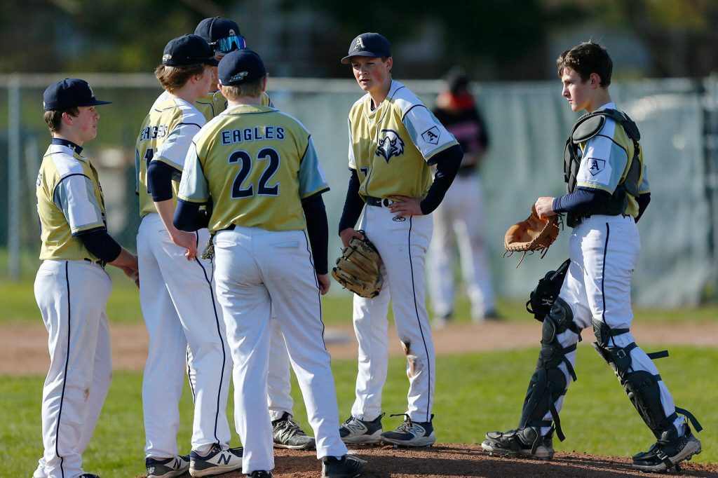 The Arlington infield meets at the mound after giving up a go-ahead run to Snohomish on Friday, April 14, 2023, at Earl Torgeson Field in Snohomish, Washington. (Ryan Berry / The Herald)