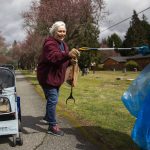 Toni Kief and her cat, Poppy, 5, smiles as she is handed a bird feather that she collects while she picks up trash on Tuesday, April 18, 2023 in Marysville, Washington. (Olivia Vanni / The Herald)