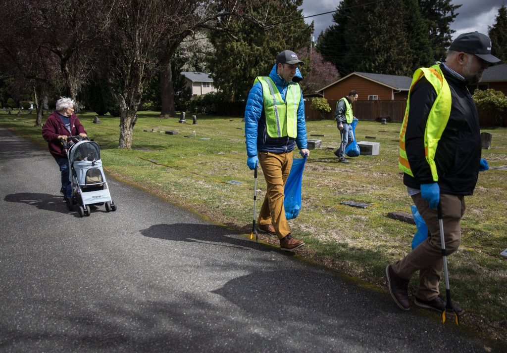 Volunteers walk through the Marysville Cemetery and pick up trash on Tuesday, April 18, 2023 in Marysville, Washington. (Olivia Vanni / The Herald)