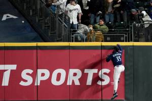 Seattle Mariners right fielder Teoscar Hernandez climbs the wall but cannot get to a home run by Milwaukee Brewers' Brice Turang during the seventh inning of a baseball game Monday, April 17, 2023, in Seattle. (AP Photo/Lindsey Wasson)