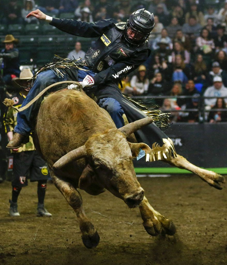 Dener Barbosa rides a bull during Unleash The Beast at Angel of the Winds Arena in Everett, Washington on Thursday, April 20, 2023. (Annie Barker / The Herald)