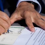 Washington Gov. Jay Inslee signs House Bill 1469, which shields abortion and gender-affirming care patients and providers from prosecution by out-of-state authorities and prevents cooperation with investigations, Thursday, April 27, 2023, at the University of Washingtons Hans Rosling Center for Population Health in Seattle. (AP Photo/Lindsey Wasson)