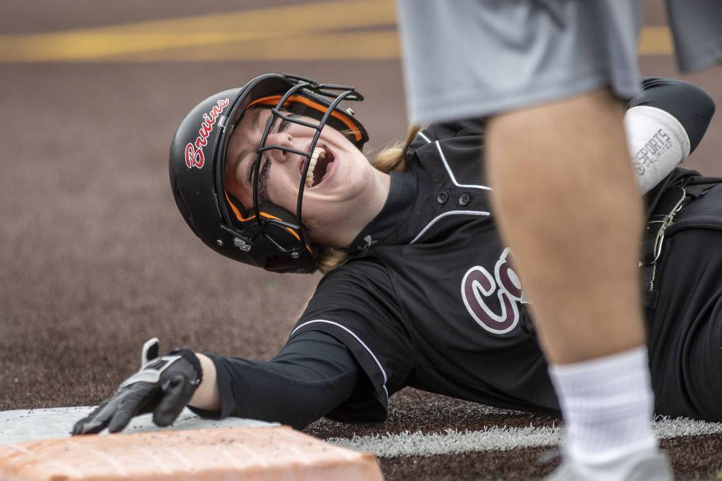 A Cascade player laughs after slipping over first base during an Everett and Cascade softball game at Phil Johnson Ballfields in Everett, Washington on Friday, April 21, 2023. Cascade won, 12-2. (Annie Barker / The Herald)