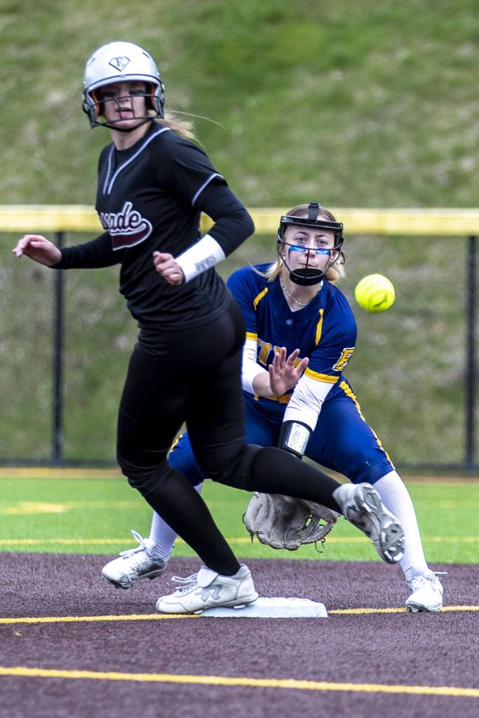 A Cascade player hits seconds and tries to run for third during an Everett and Cascade softball game at Phil Johnson Ballfields in Everett, Washington on Friday, April 21, 2023. Cascade won, 12-2. (Annie Barker / The Herald)