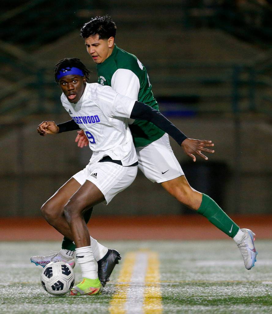 Shorewoods Anthony Henry holds off a defender while looking for a passing lane during overtime against Edmonds-Woodway on Friday, April 21, 2023, at Edmonds Stadium in Edmonds, Washington. (Ryan Berry / The Herald)
