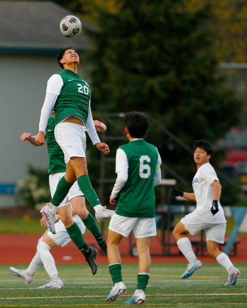 Edmonds-Woodway defender Antony Cesar takes to the air to head the ball away against Shorewood on Friday, April 21, 2023, at Edmonds Stadium in Edmonds, Washington. (Ryan Berry / The Herald)