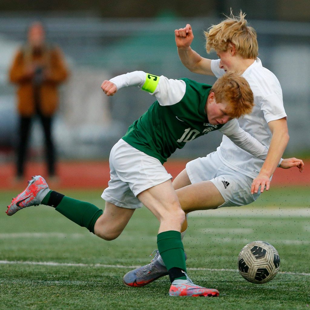 Edmonds-Woodway senior Ben Hanson collides with a defender while working up the field against Shorewood on Friday, April 21, 2023, at Edmonds Stadium in Edmonds, Washington. (Ryan Berry / The Herald)