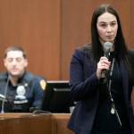 Sarah Johnson walks past the jury while speaking with Everett Police officer Brian Bratlien, background, during the first day of the trial of Shayne Baker on Monday, April 24, 2023, at Snohomish County Superior Court in Everett, Washington. (Ryan Berry / The Herald)