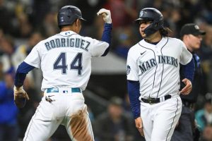 Seattle Mariners' Julio Rodriguez celebrates with Eugenio Suarez (28) after they scored against the St. Louis Cardinals during the sixth inning of a baseball game Friday, April 21, 2023, in Seattle. (AP Photo/Caean Couto)