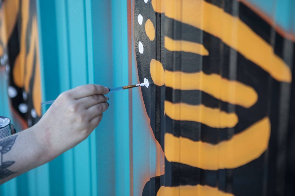 Megan McDermott paints a mural at the Mukilteo Boys & Girls Club in Mukilteo, Washington on Wednesday, April 26, 2023. Their generator was stolen and delayed the project. (Annie Barker / The Herald)