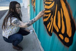 Megan McDermott paints a mural at the Mukilteo Boys & Girls Club in Mukilteo, Washington on Wednesday, April 26, 2023. Her generator was stolen and delayed the project. (Annie Barker / The Herald)