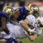 Stanford running back Casey Filkins dives for yardage while being tackled by Washington linebackers Dominique Hampton, left, and Alphonzo Tuputala, top, during the first half of an NCAA college football game Saturday, Sept. 24, 2022, in Seattle. (AP Photo/Stephen Brashear)