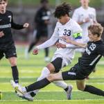 Glacier Peaks Azavier Coppin is slide tackled by Jacksons Sam Russel during the game on Friday, April 28, 2023 in Snohomish, Washington. (Olivia Vanni / The Herald)