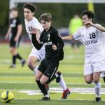 Jacksons Vitaliy Nagomyy beats to Glacier Peak players to the ball during the game on Friday, April 28, 2023 in Snohomish, Washington. (Olivia Vanni / The Herald)