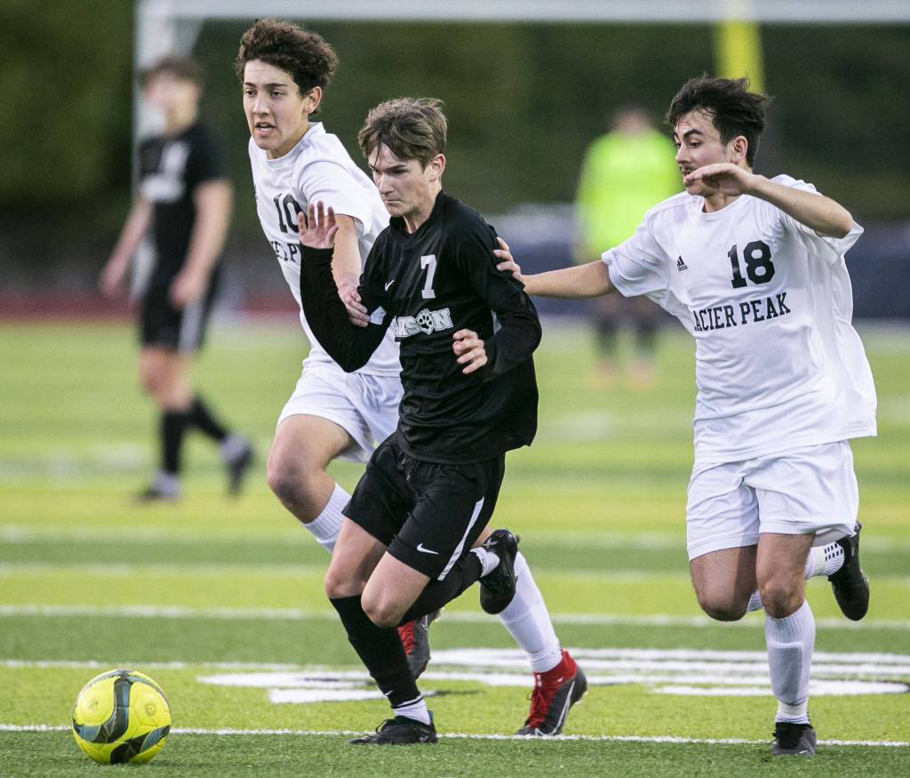 Jacksons Vitaliy Nagomyy beats to Glacier Peak players to the ball during the game on Friday, April 28, 2023 in Snohomish, Washington. (Olivia Vanni / The Herald)