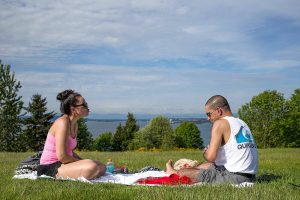 Tawny Mandracken blows a teasing kiss at her husband Garrick after he lost a round of cards as they duo enjoys the sunny weather at Harborview Park on Tuesday, May 9, 2017 in Everett, Wa. (Andy Bronson / The Herald)
