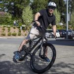 Edmonds Mayor Mike Nelson hops on a bike during Bike to School Day. (Annie Barker / The Herald)
