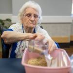 Ellen Douglas fills a bag with brown rice for Faith Food Bank donations on Tuesday, May 2, 2023 in Everett, Washington. (Olivia Vanni / The Herald)