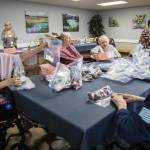 Ellen Douglas fills a bag with beans for Faith Food Bank donations on Tuesday, May 2, 2023 in Everett, Washington. (Olivia Vanni / The Herald)