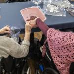 Marilyn Naylor, left, helps Katherine Audas fill a bag with dry beans on Tuesday, May 2, 2023 in Everett, Washington. (Olivia Vanni / The Herald)