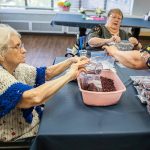 A group of Bethany senior residents fill bags with dry goods for the Faith Food Bank on Tuesday, May 2, 2023 in Everett, Washington. (Olivia Vanni / The Herald)