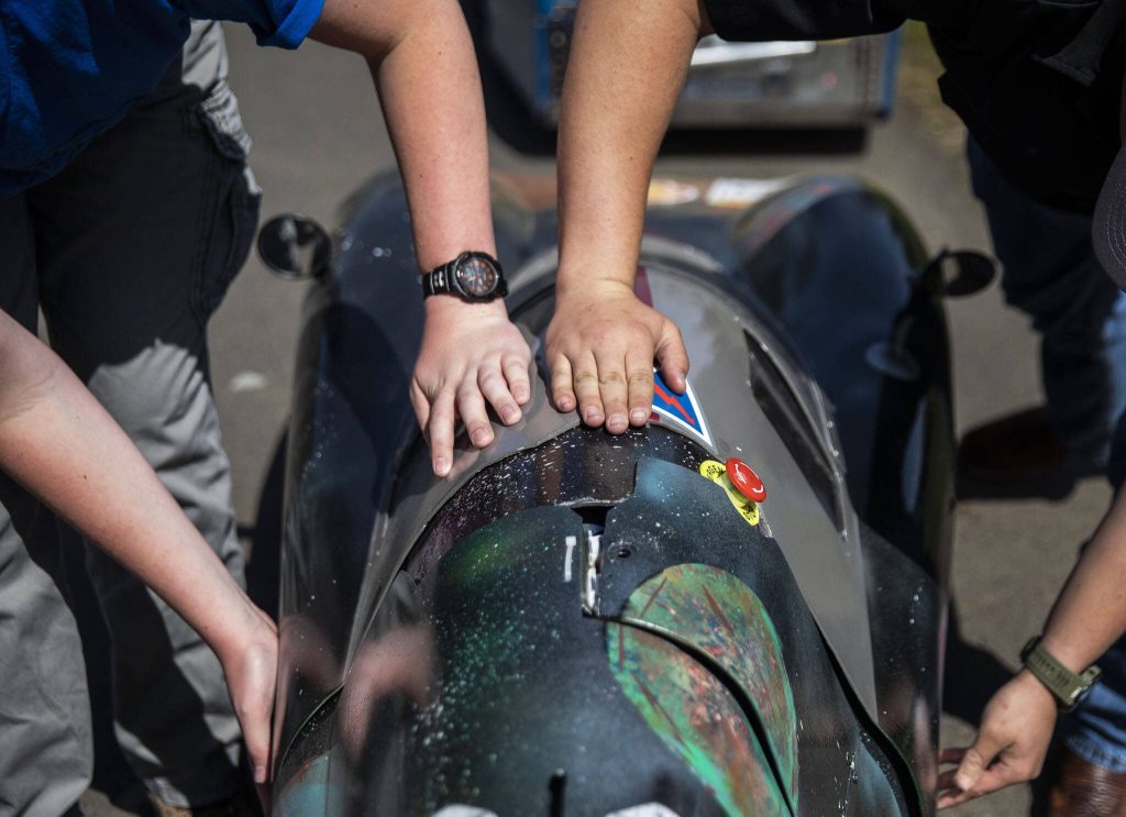 Greyson Clevenger and Andrew Dee close the opening to the teams battery electric prototype car on Thursday, April 27, 2023 in Granite Falls, Washington. (Olivia Vanni / The Herald)