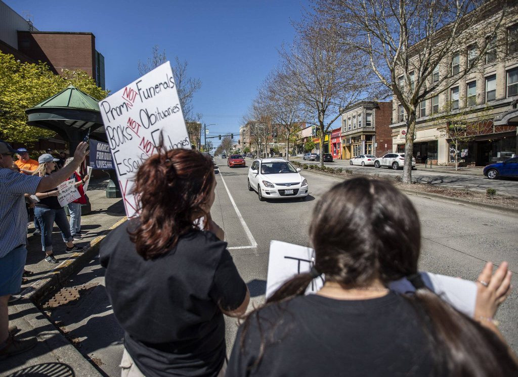 Protesters acknowledge waves and honks from passersby. (Olivia Vanni / The Herald)