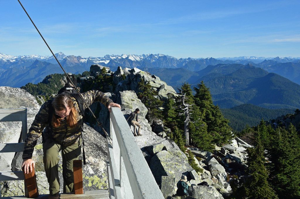 Hikers soak up the sun and views near the Mount Pilchuck fire lookout in early November 2019. (Caleb Hutton / The Herald)