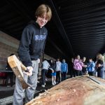 Tim Thomas, a ninth grader at Archbishop Murphy High School helps work on a community carving project on Friday, May 5, 2023 in Everett, Washington. (Olivia Vanni / The Herald)