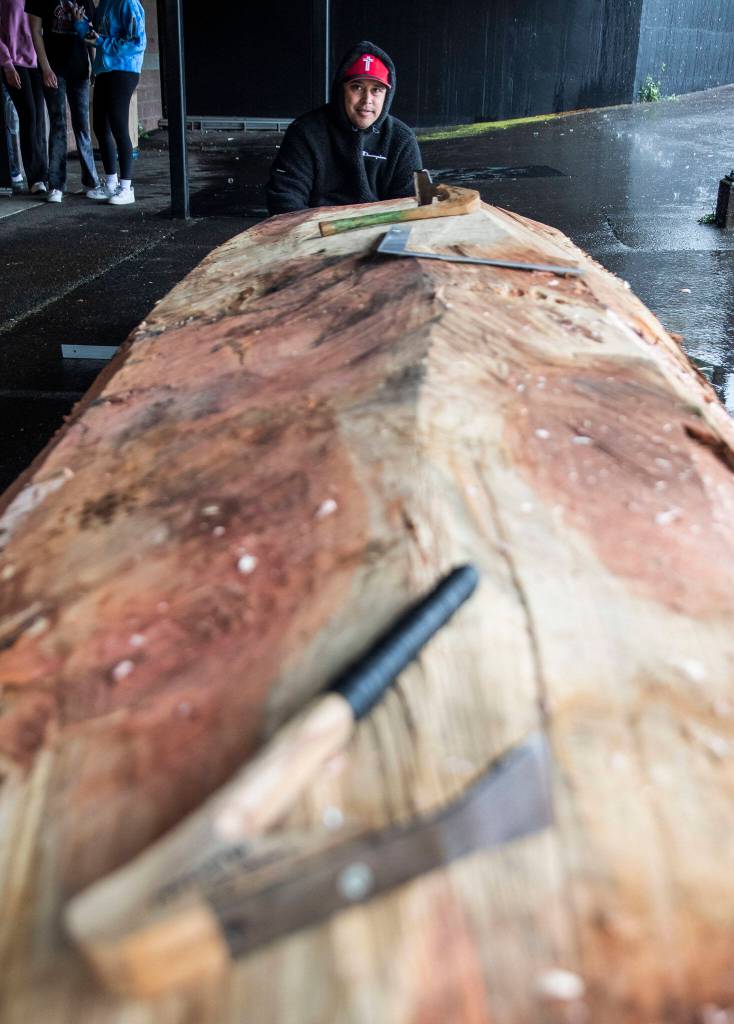 Artist James Madison, who will take the lead on the carving looks across the 12 foot piece of wood on Friday, May 5, 2023 in Everett, Washington. (Olivia Vanni / The Herald)