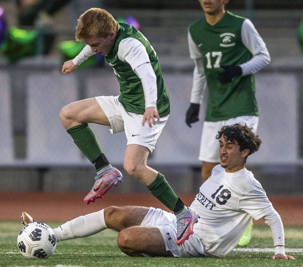 Edmonds Ben Hanson leaps over a slide tackle by Everetts Nussrat Nussrat during the game on Monday, May 1, 2023 in Edmonds, Washington. (Olivia Vanni / The Herald)