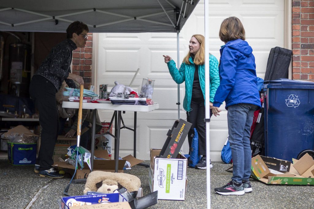 People look at items during a garage sale in Mill Creek, Washington on Saturday, May 6, 2023. (Annie Barker / The Herald)
