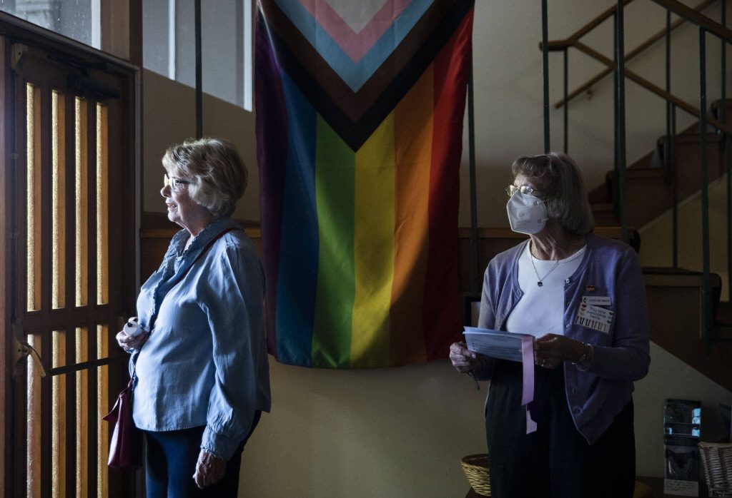 Greeters hand out programs as people begin to file in for the vigil at Edmonds United Methodist Church on Tuesday, May 2, 2023 in Edmonds, Washington. (Olivia Vanni / The Herald)