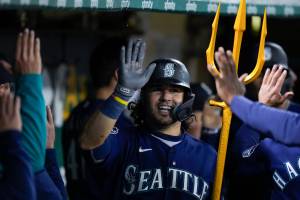 The Mariners Eugenio Suárez celebrates with teammates in the dugout after hitting a three-run home run against the Athletics during the 10th inning of a game Wednesday in Oakland, Calif. (AP Photo/Godofredo A. Vásquez)