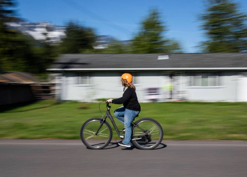 A student rides down a road during a bike safety exercise at Darrington Elementary School on Friday, May 12, 2023 in Darrington, Washington. (Olivia Vanni / The Herald)