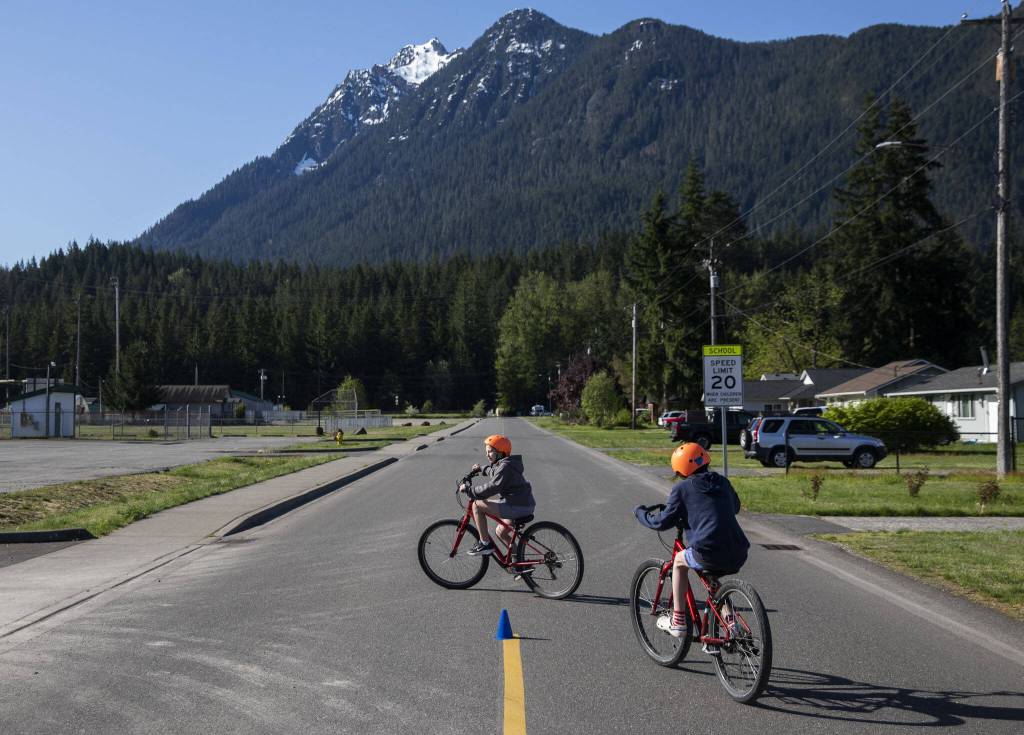 Students make left turns across a road during a bike safety class at Darrington Elementary School on Friday, May 12, 2023 in Darrington, Washington. (Olivia Vanni / The Herald)