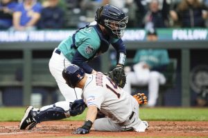 Seattle Mariners catcher Tom Murphy, top, tags out Houston Astros' Mauricio Dubon at home during the fifth inning of a baseball game Saturday, May 6, 2023, in Seattle. (AP Photo/Lindsey Wasson)