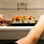 Levi Arneson, 12, grabs a roll from the monorail system next to his table at Sushi Hana on Jan. 5, in Lynnwood. (Ryan Berry / The Herald)