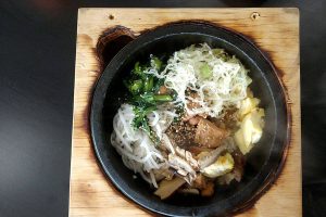 The sizzling-hot bibimbap bowls at K Fresh in Everett are served in wood boxes, which acquire charred edges from the hot stone. (Sara Bruestle / The Herald)