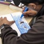 Giovanni S. works on an an orca drawing in the art studio at the Everett Recovery Cafe on Wednesday, May 10, 2023 in Everett, Washington. (Olivia Vanni / The Herald)