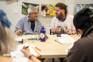 Joseph Anderson, right, chats with Steve Manshour during Art Studio time at the Everett Recovery CaFE on Wednesday, May 10, 2023 in Everett, Washington. (Olivia Vanni / The Herald)