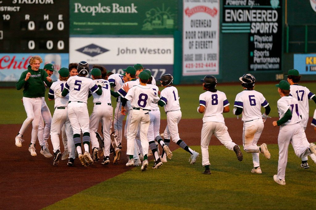 Edmonds-Woodway players mob captain Jens Simonsen after he ended the game via the slaughter rule with a double against Ferndale in a Wesco 3A District 1 semifinal on Tuesday, May 9, 2023, at Funko Field in Everett, Washington. (Ryan Berry / The Herald)